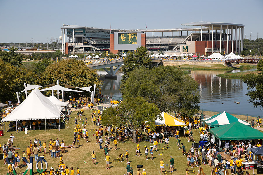 view of the student tailgating area with the Brazos River and McLane Stadium in the background